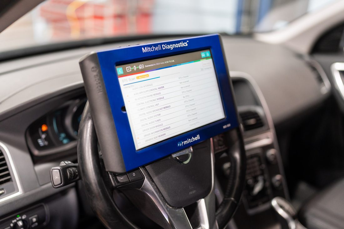 Diagnostic scan tool reading control module fault codes inside a vehicle
