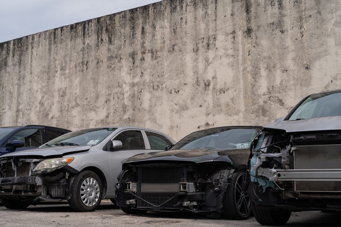 A row of damaged vehicles in for insurance repair work