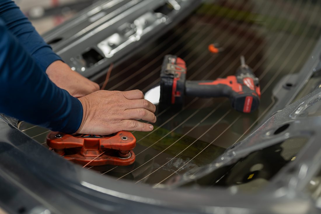 Rear glass being cut free with a wire tool during disassembly
