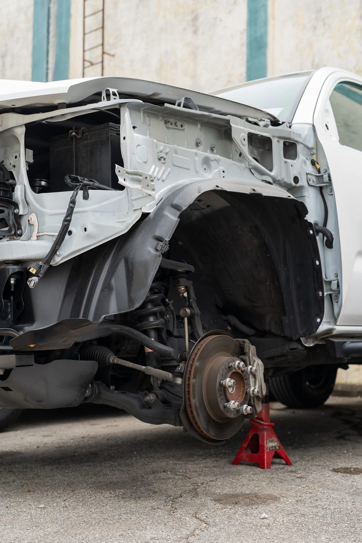 Front fender, wheel liner and suspension exposed on jack stands